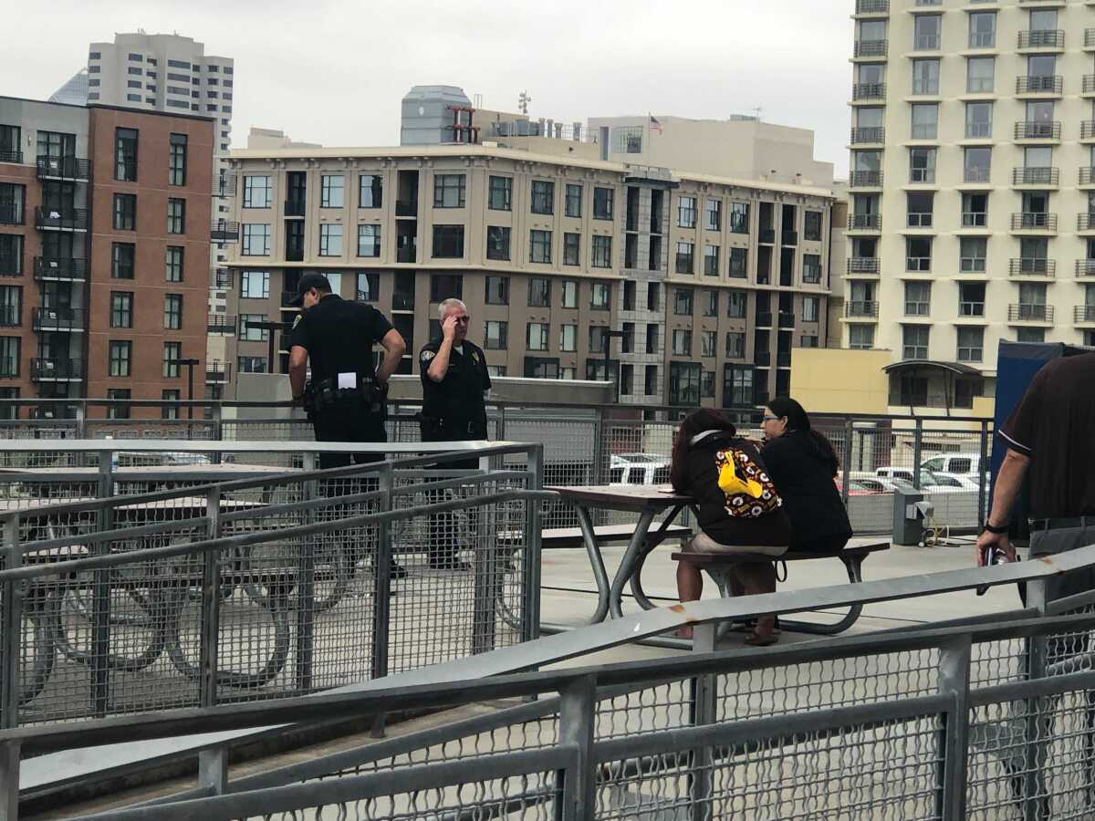 SDPD officers stand near railing on Petco Park concourse where a mother and son fell to their deaths Saturday afternoon.