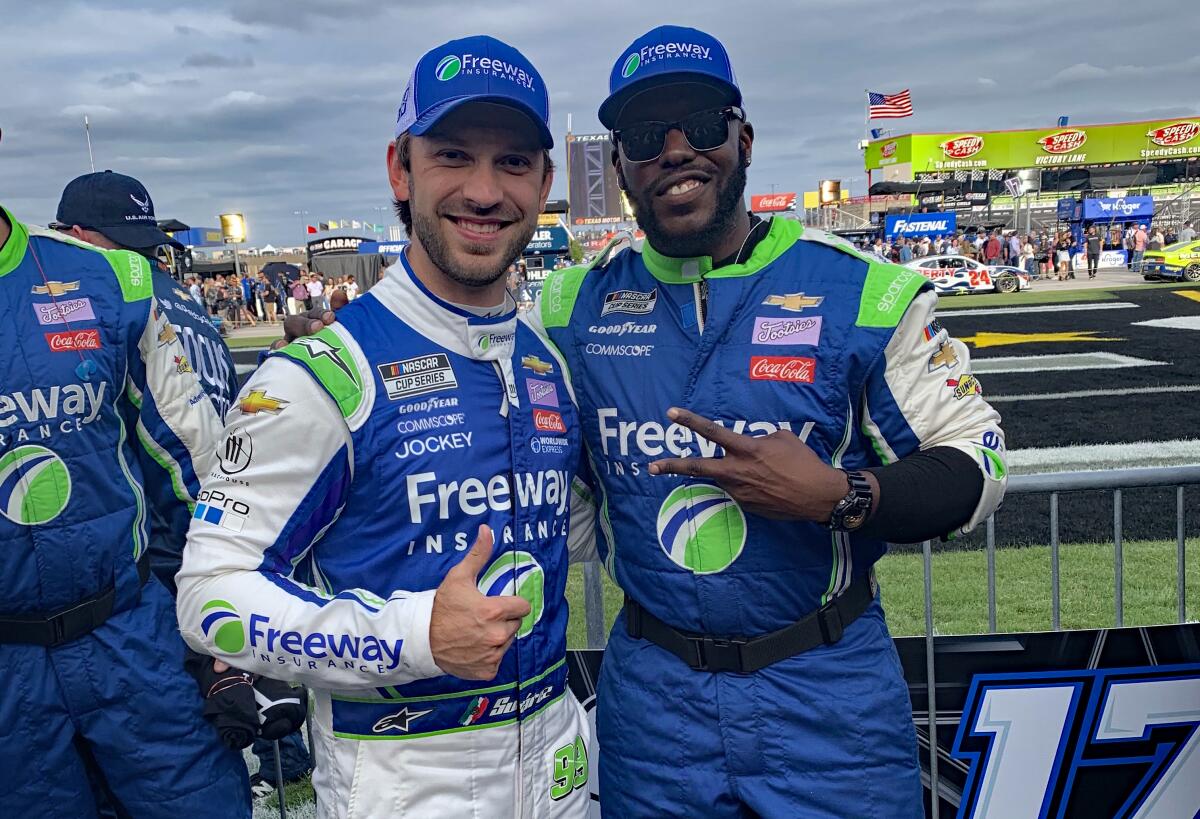 Trackhouse Racing pit crew member Jeremy Kimbrough, right, poses next to NASCAR Cup driver Daniel Suárez.