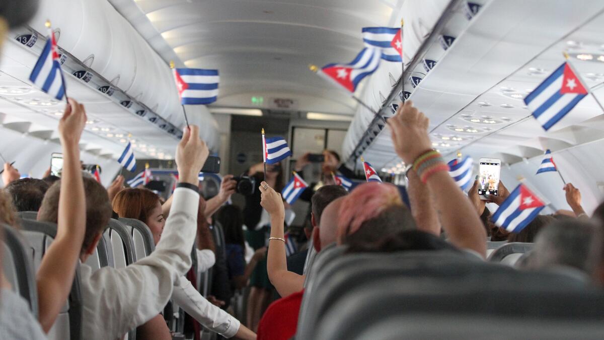 Passengers wave Cuban flags during JetBlue's inaugural commercial flight to Cuba on Wednesday.