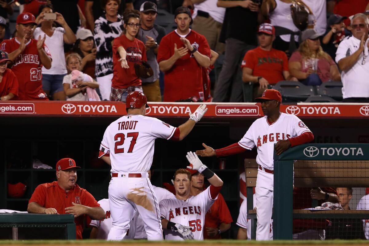 Angels Manager Mike Scioscia and outfielder Kole Calhoun congratulate outfielder Mike Trout after his solo home run during the fourth inning on Sept. 26.