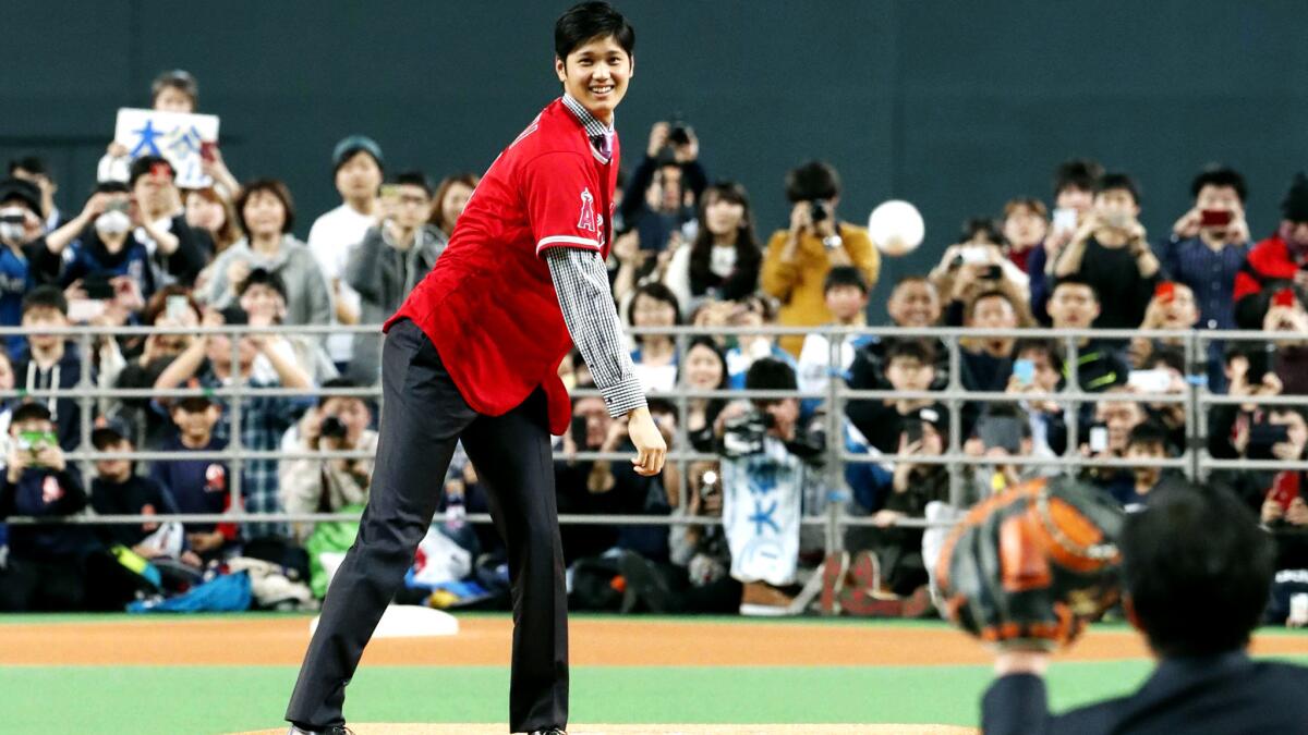 Shohei Ohtani throws a ceremonial pitch during a news conference Monday.