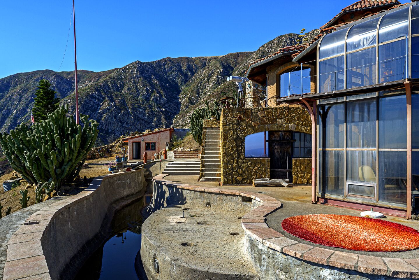 The house sits on a 13.31-acre site and has a partially completed swimming pool/moat.