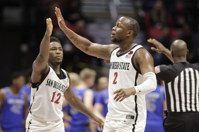 SAN DIEGO, CA - DECEMBER 28, 2022: The Aztecs' Adam Seiko, right, and Darrion Trammell celebrate their lead over Air Force as they walk off the court for a timeout during the second half at the Viejas Arena in San Diego on Wednesday, December 28, 2022. (Hayne Palmour IV / For The San Diego Union-Tribune)