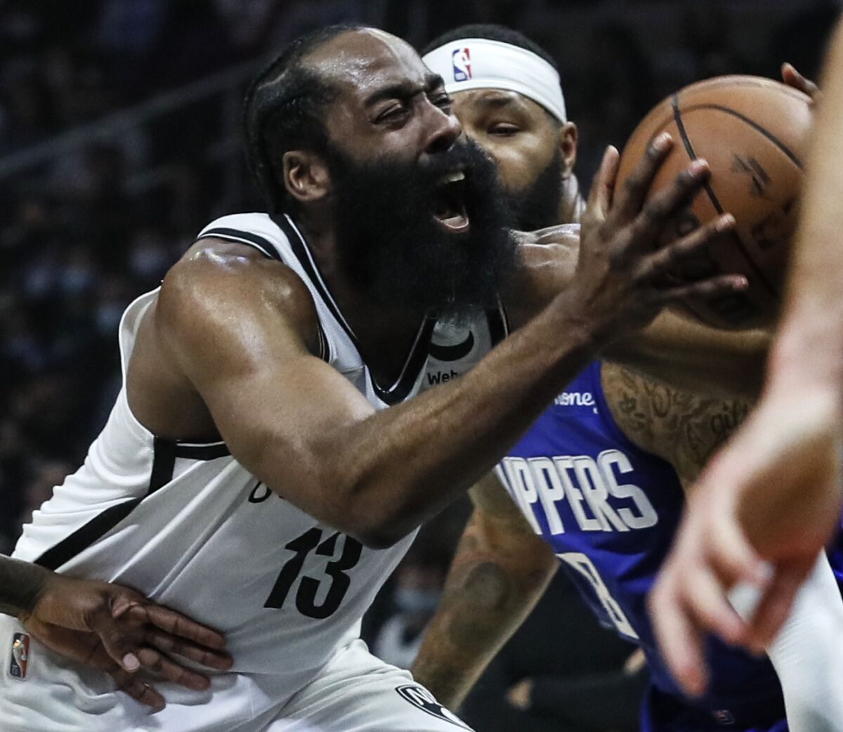 Brooklyn Nets guard James Harden strains to get past Clippers forward Marcus Morris Sr.