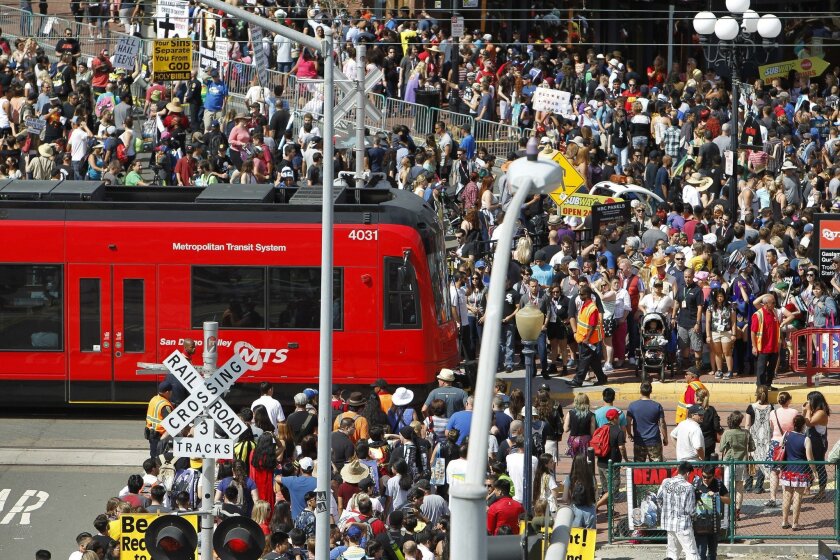 Crowds of people and the San Diego Trolley at the end of Fifth Avenue during day three of Comic-Con in San Diego last year.