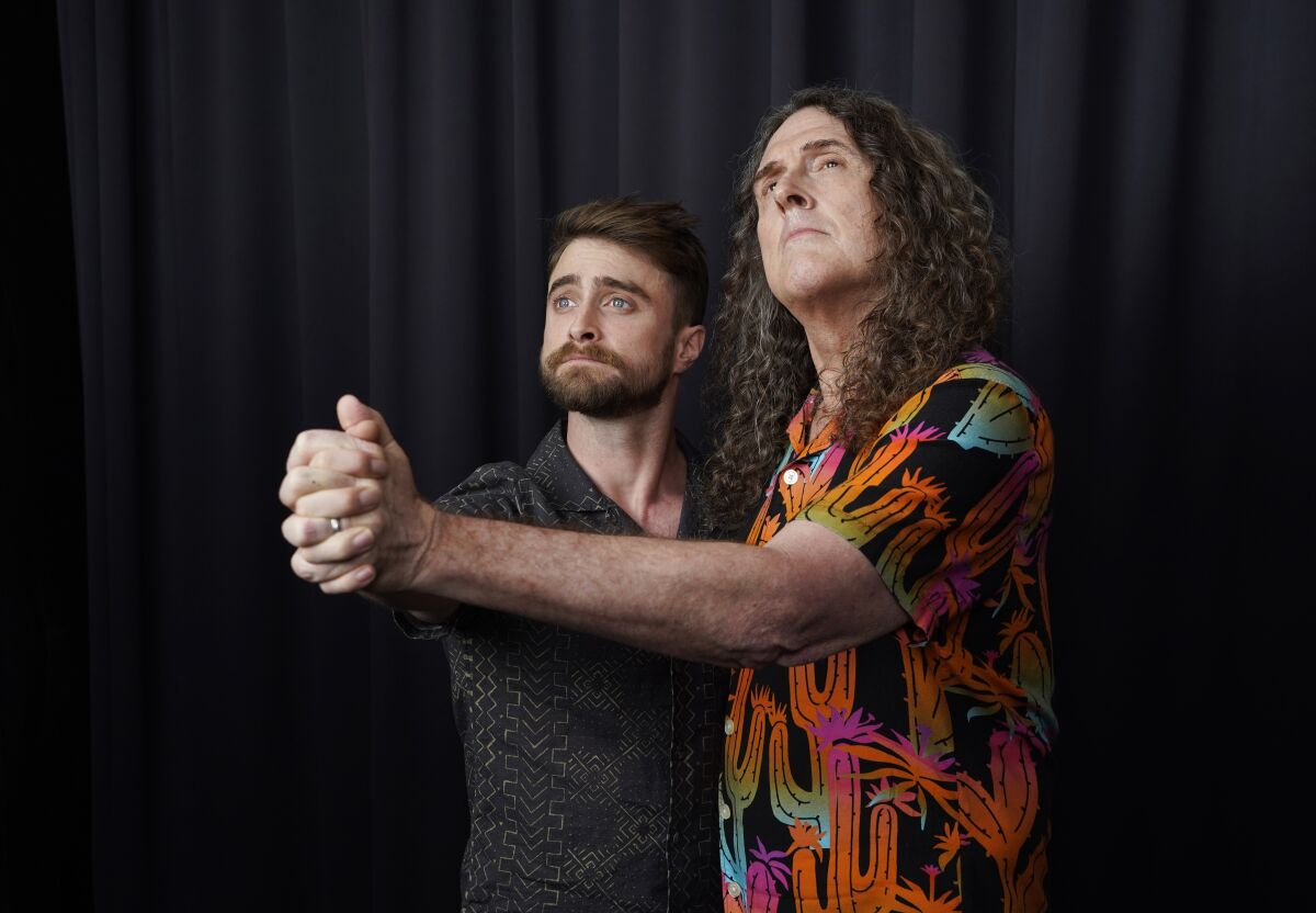 Daniel Radcliffe, left, and "Weird Al" Yankovic strike a pose for a portrait at the Bisha Hotel, during the Toronto International Film Festival, Thursday, Sept. 8, 2022, in Toronto. Radcliffe plays Yankovic in the film "Weird: The Al Yankovic Story." (AP Photo/Chris Pizzello)