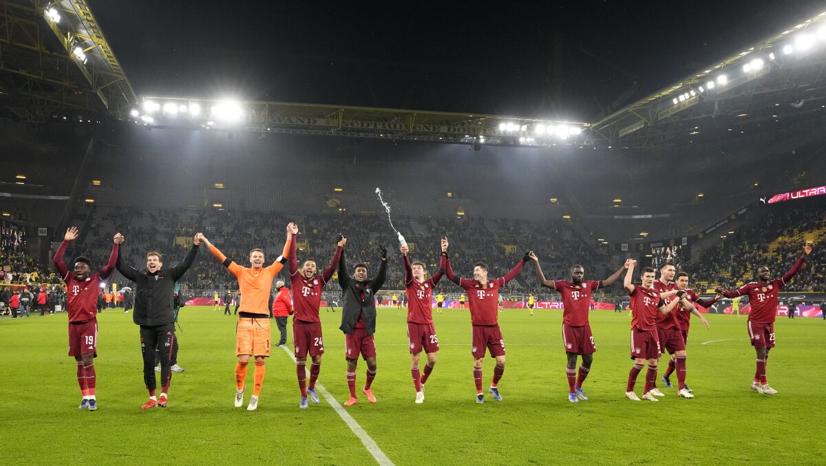 Bayern players celebrate at the end of the German Bundesliga soccer match between Borussia Dortmund and Bayern Munich in Dortmund, Germany, Saturday, Dec. 4, 2021. Bayern won the match 3-2. (AP Photo/Martin Meissner)