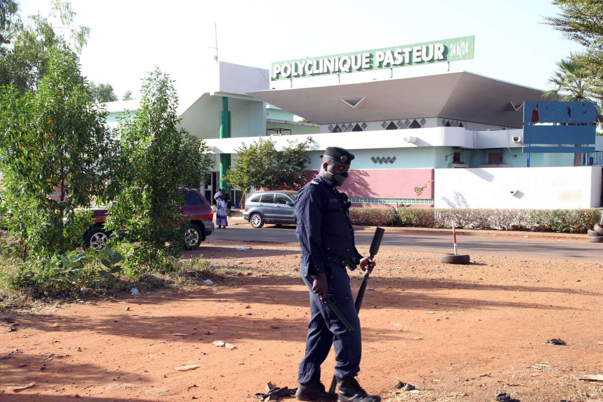 A police officer stands outside the quarantined Pasteur Clinic in Mali's capital, Bamako, on Nov. 12, 2014.