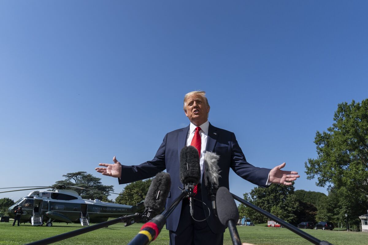 President Donald Trump speaks with reporters as he walks to Marine One on the South Lawn of the White House, Monday, Aug. 17, 2020, in Washington. Trump is en route to Minnesota and Wisconsin. (AP Photo/Alex Brandon)