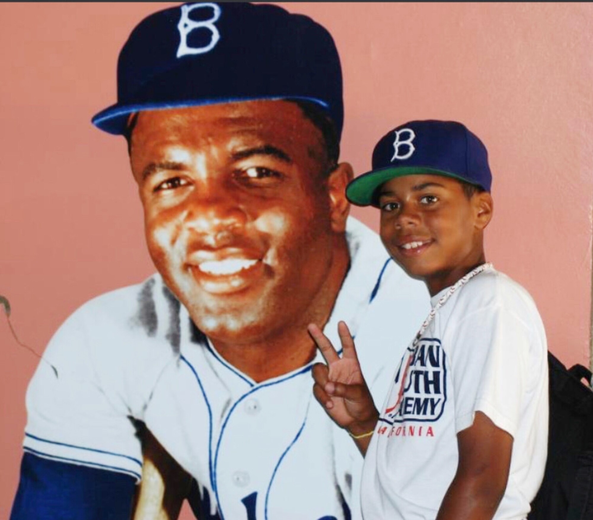 A young Hunter Greene stands in front of a photo of Dodgers legend Jackie Robinson.
