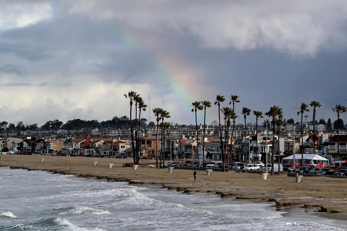 A rainbow spotted from the north side of Newport Beach Pier as storm clouds push inland on Friday.