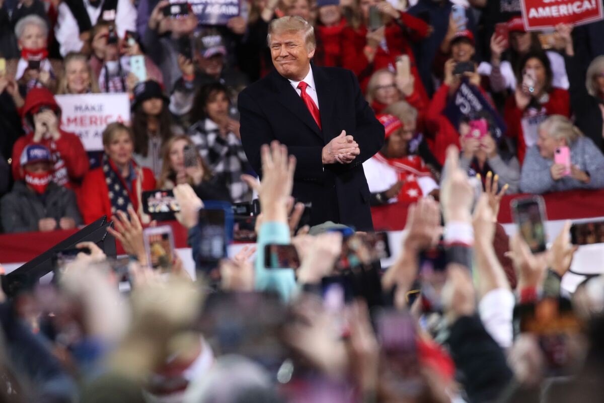 President Trump at a rally surrounded by people.