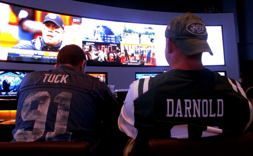 FILE - This Sept. 9, 2018 file photo shows fans of the New York Giants and Jets watching a football game after placing bets in the sports betting lounge at the Ocean Casino Resort in Atlantic City, N.J. The American Gaming Association estimates more than 31 million people will bet on Sunday's Super Bowl. (AP Photo/Wayne Parry, FILE)