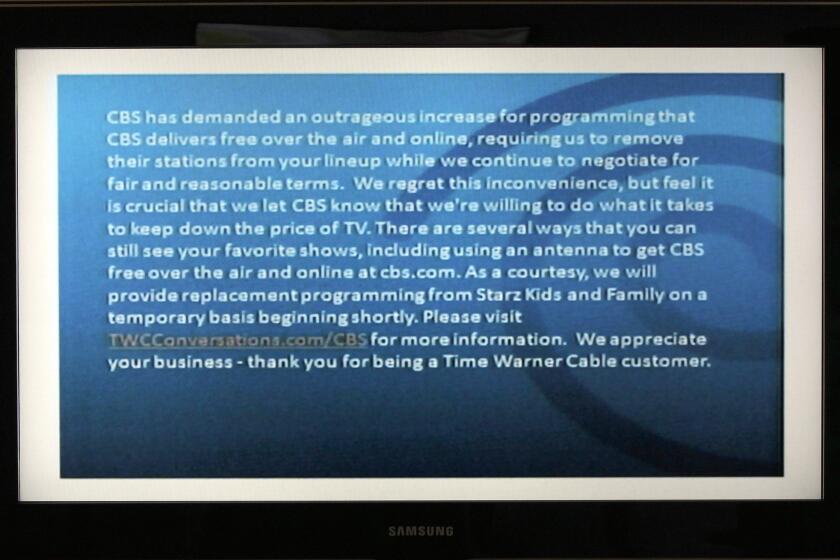 A television screen shows the CBS channel with an announcement by Time Warner Cable in Los Angeles.