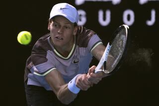 Jannik Sinner of Italy plays a backhand return to Novak Djokovic of Serbia.