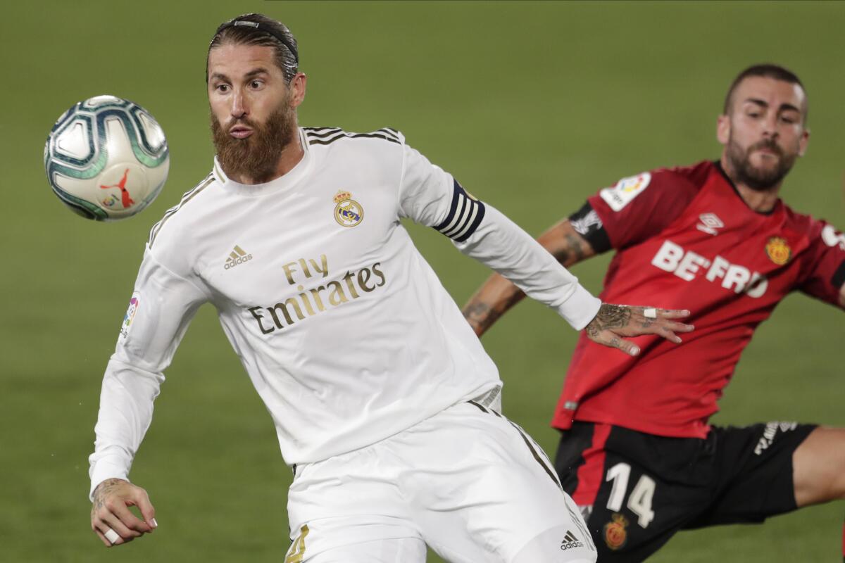 Real Madrid's Sergio Ramos fights for the ball with Mallorca's Dani Rodriguez.