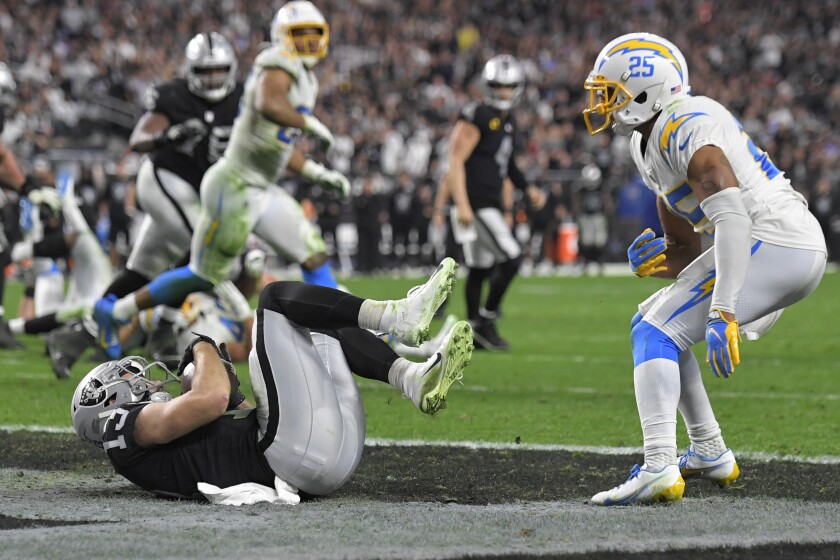 Las Vegas Raiders wide receiver Hunter Renfrow (13) scores a touchdown against Los Angeles Chargers cornerback Chris Harris (25) during the second half of an NFL football game, Sunday, Jan. 9, 2022, in Las Vegas. (AP Photo/David Becker)