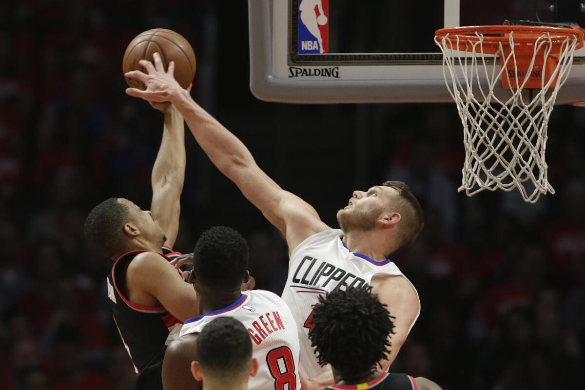 Clippers center Cole Aldrich blocks the shot of Portland's C.J. McCollum during a game last season.