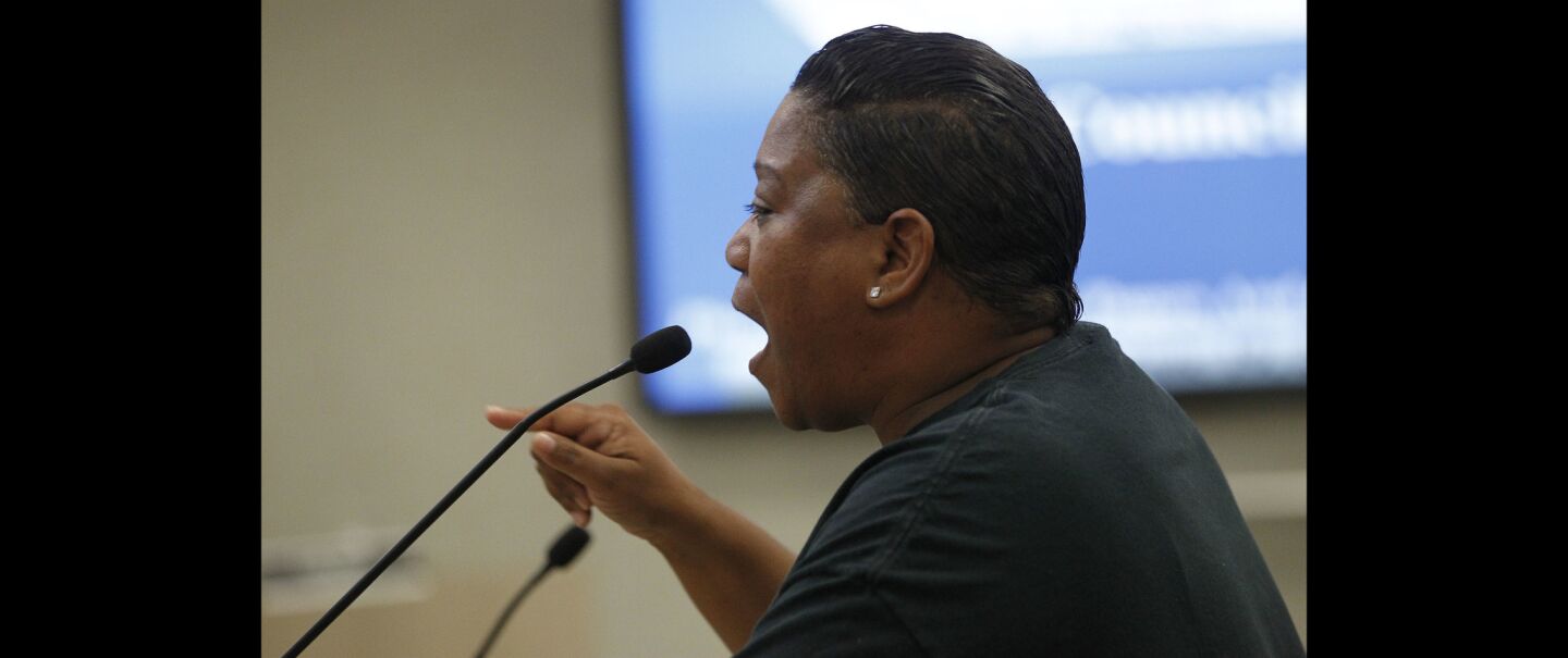 Civil rights activist Tasha Williamson yells toward city council members.