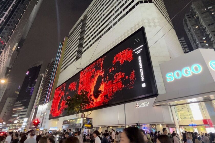 In this undated image released by Art Innovation Gallery, Patrick Amadon's "No Rioters" digital artwork is seen on the billboard of the SOGO shopping mall in Hong Kong. The Hong Kong department store took down a digital artwork that contained hidden references to jailed dissidents, in an incident the artist says is evidence of erosion of free speech in the semi-autonomous Chinese city. (Art Innovation Gallery via AP)