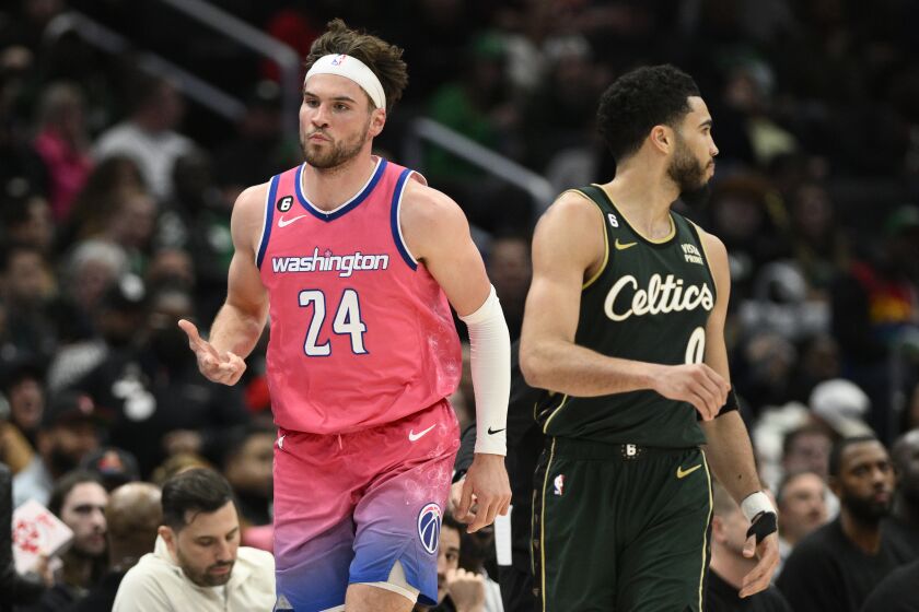 Corey Kispert, alero de los Wizards de Washington, festeja tras anotar un triple, junto a Jayson Tatum, de los Celtics de Boston, el martes 28 de marzo de 2023 (AP Foto/Nick Wass)