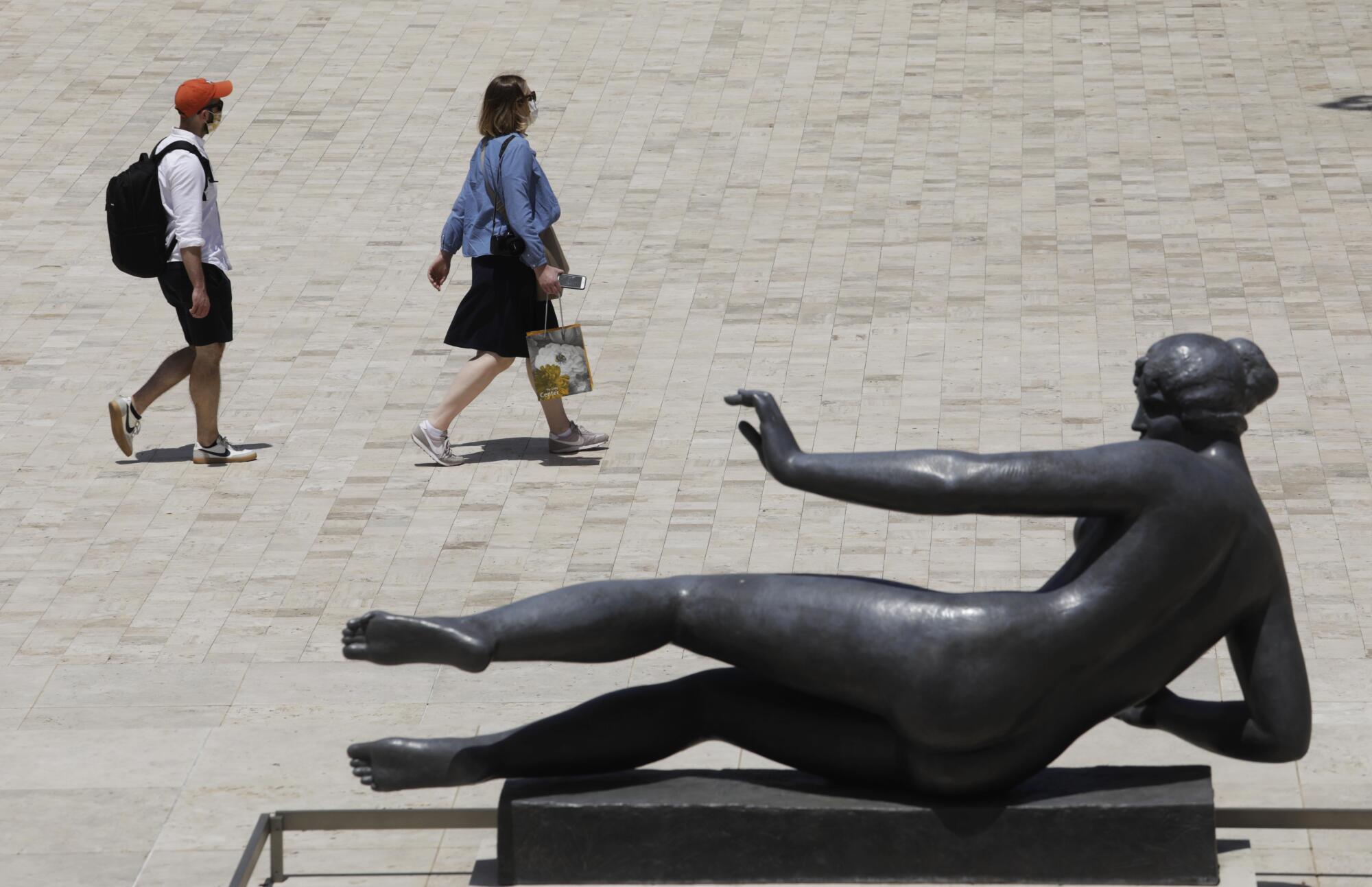 Two visitors walk past the sculpture "Air" by Aristide Maillol.