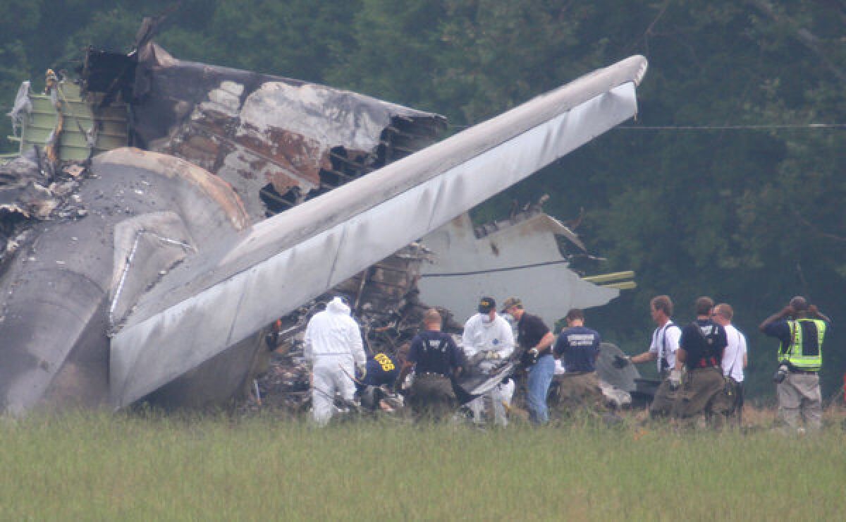 Investigators remove debris from the tail section of the UPS cargo plane that crashed Wednesday in Birmingham, Ala.