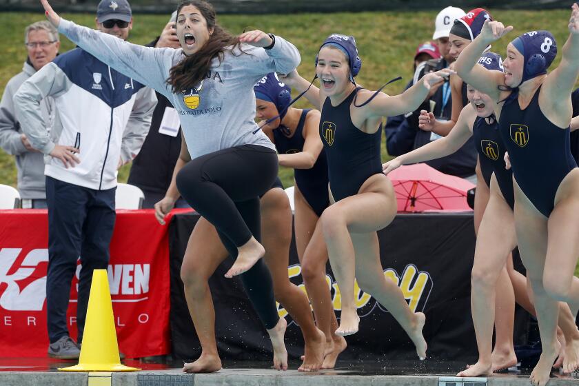 Marina head coach Tamara Towgood, left, leads her players into the pool after the Vikings defeat Flintridge Prep 6-4 in the CIF Southern Section Division VI championship match at Woollett Aquatics Center in Irvine on Saturday.