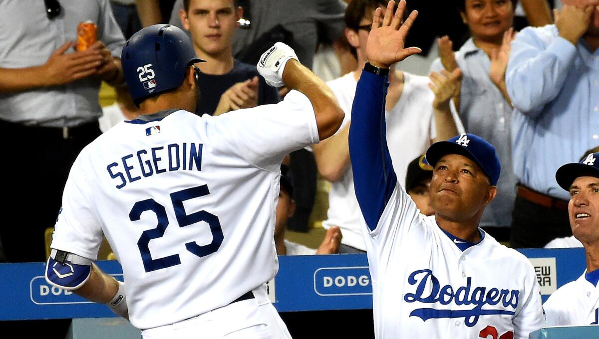 Dodgers outfielder Rob Segedin is greeted by Manager Dave Roberts after a solo home run against the Giants in the second inning Tuesday.