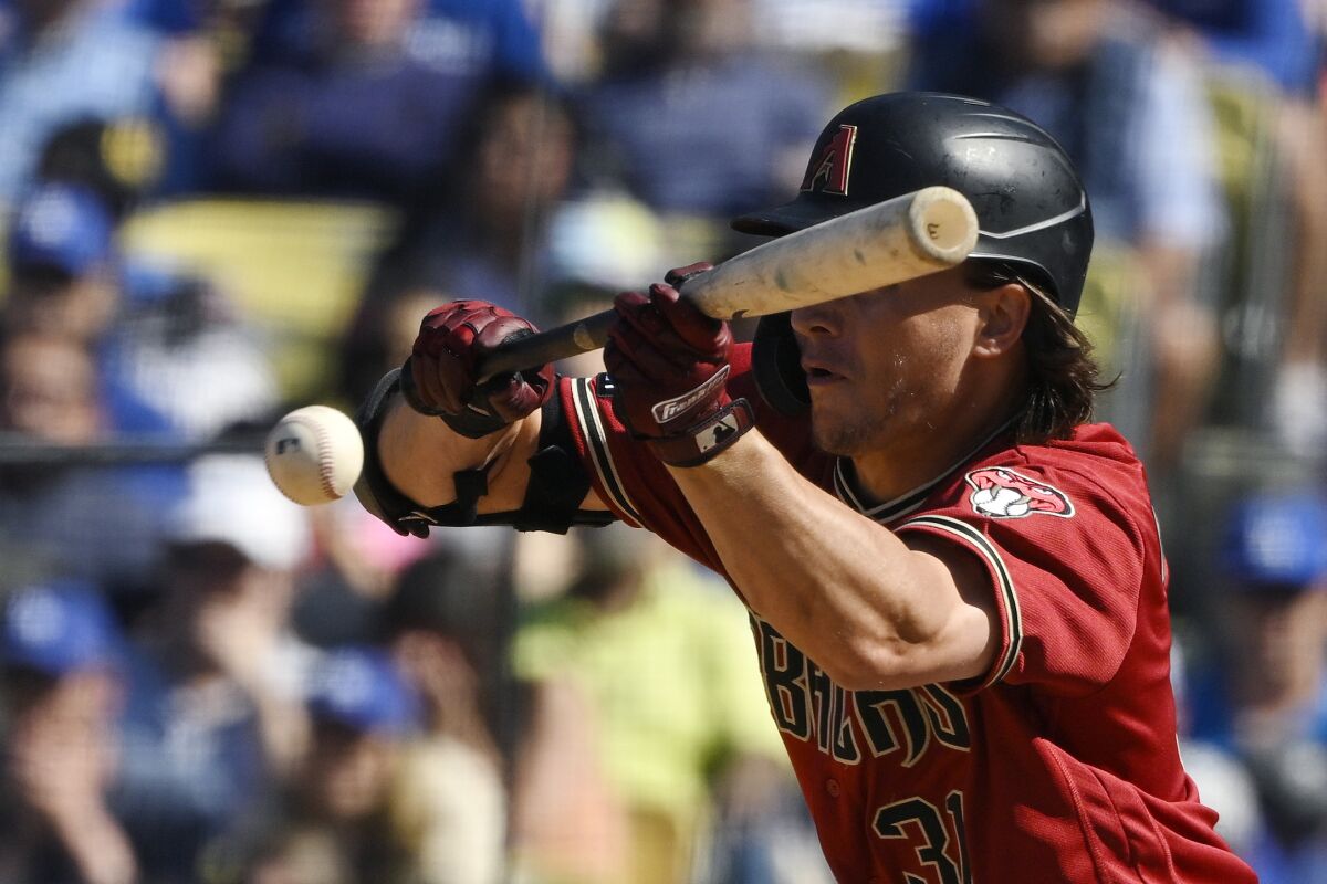 Arizona's Jake McCarthy puts down a bunt during the ninth inning.