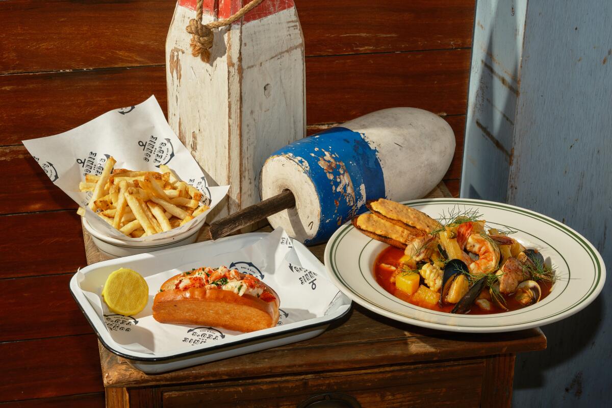 plate of lobster roll with bowl of fries and another bowl of gumbo