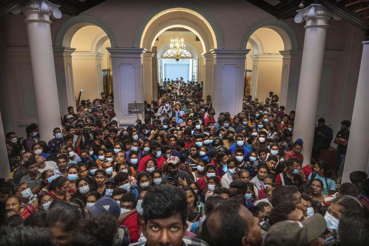 People throng President Gotabaya Rajapaksa's official residence for the second day after it was stormed in Colombo, Sri Lanka, Monday, July 11, 2022. (AP Photo/Rafiq Maqbool)