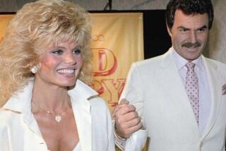 FILE - In this March 27, 1987 file photo, Burt Reynolds, right, holds hands with Loni Anderson at luncheon in Los Angeles. Reynolds, who starred in films including "Deliverance," "Boogie Nights," and the "Smokey and the Bandit" films, died at age 82, according to his agent. (AP Photo/Bob Galbraith, File)