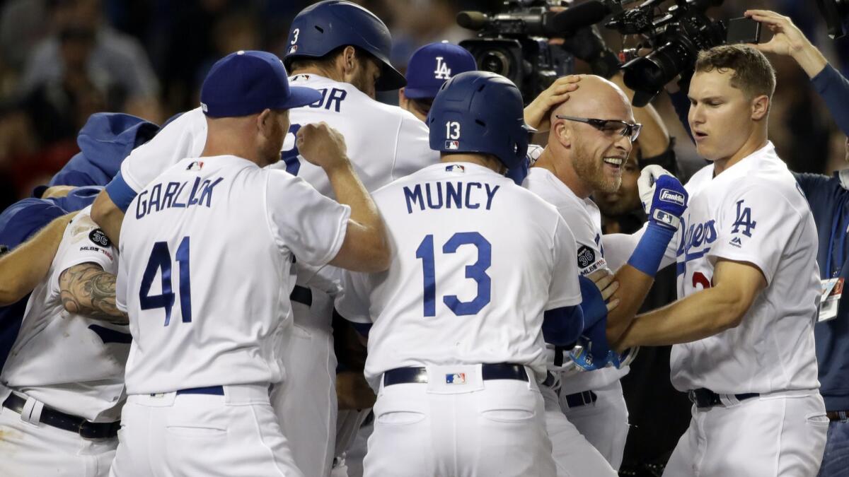 The Dodgers' Matt Beaty, second from right, is surrounded by teammates after his walk-off two-run home run against the Colorado Rockies during the ninth inning on Friday at Dodger Stadium.