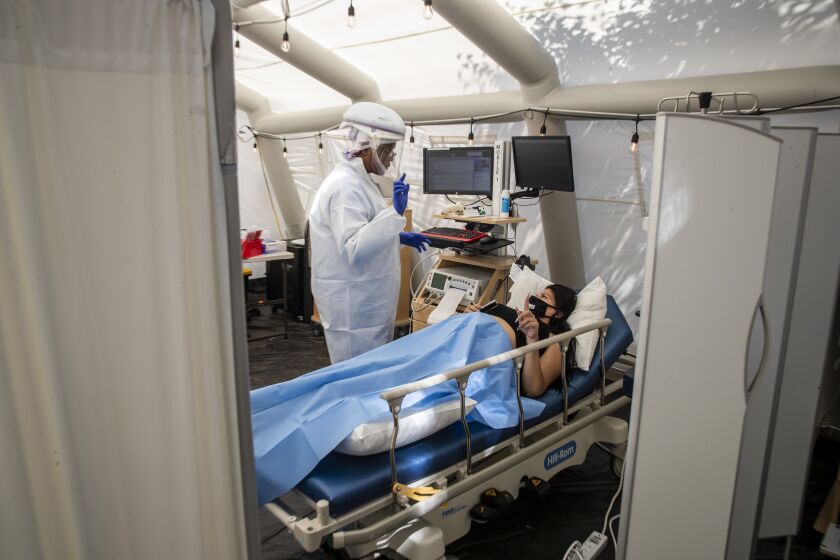 MISSION HILLS, CA - JULY 10: Nurse Janil Wise (CQ), left, screens patient Sarah Bodle, who is pregnant and was exposed to a person with COVID-19, in the OB triage tent at Providence Holy Cross Medical Center on Friday, July 10, 2020 in Mission Hills, CA. (Brian van der Brug / Los Angeles Times)