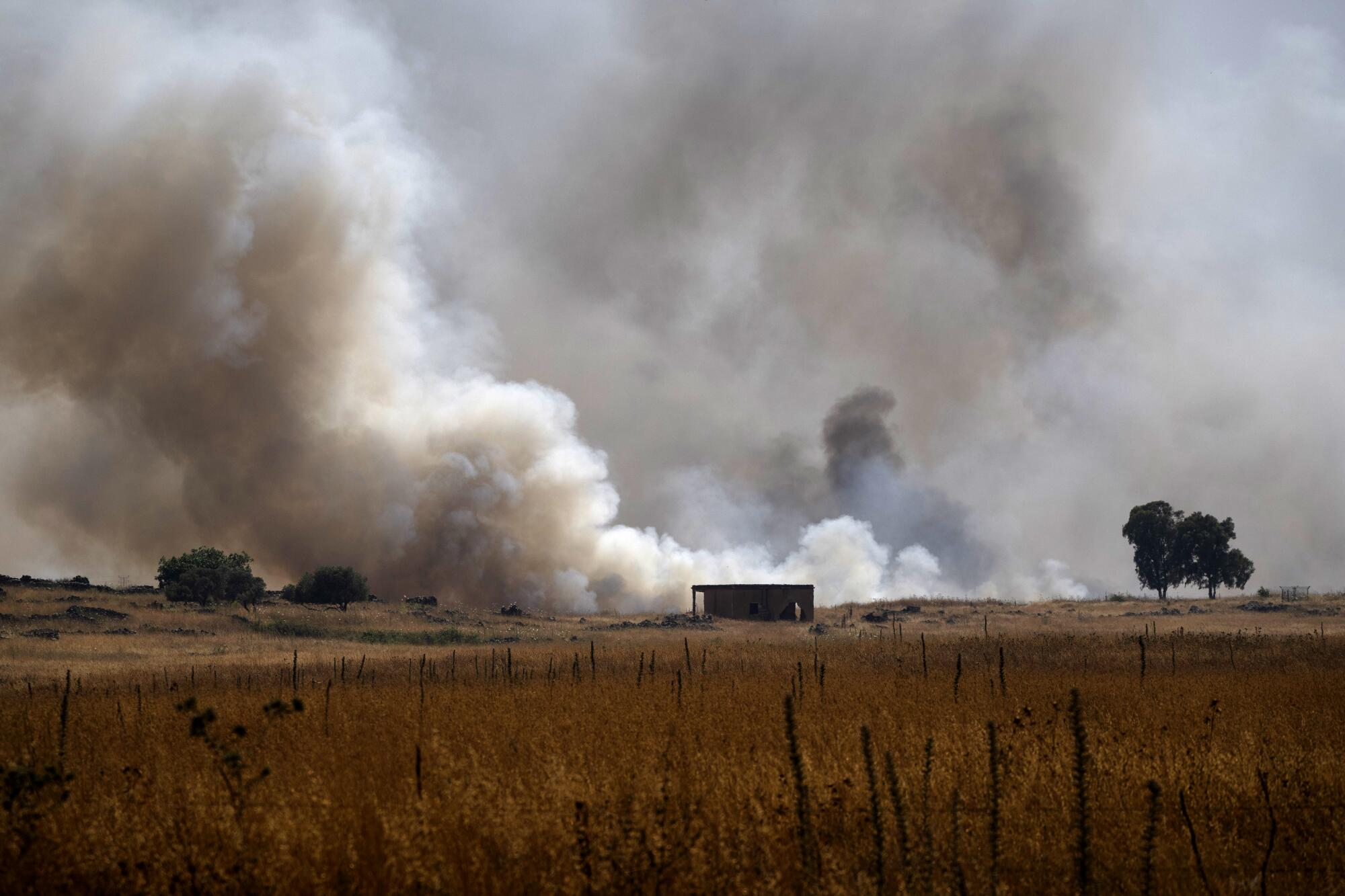 农田里发生火灾，烟雾升上天空。