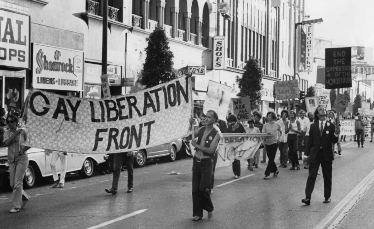 Marchers in a parade hold a "Gay Liberation Front" banner