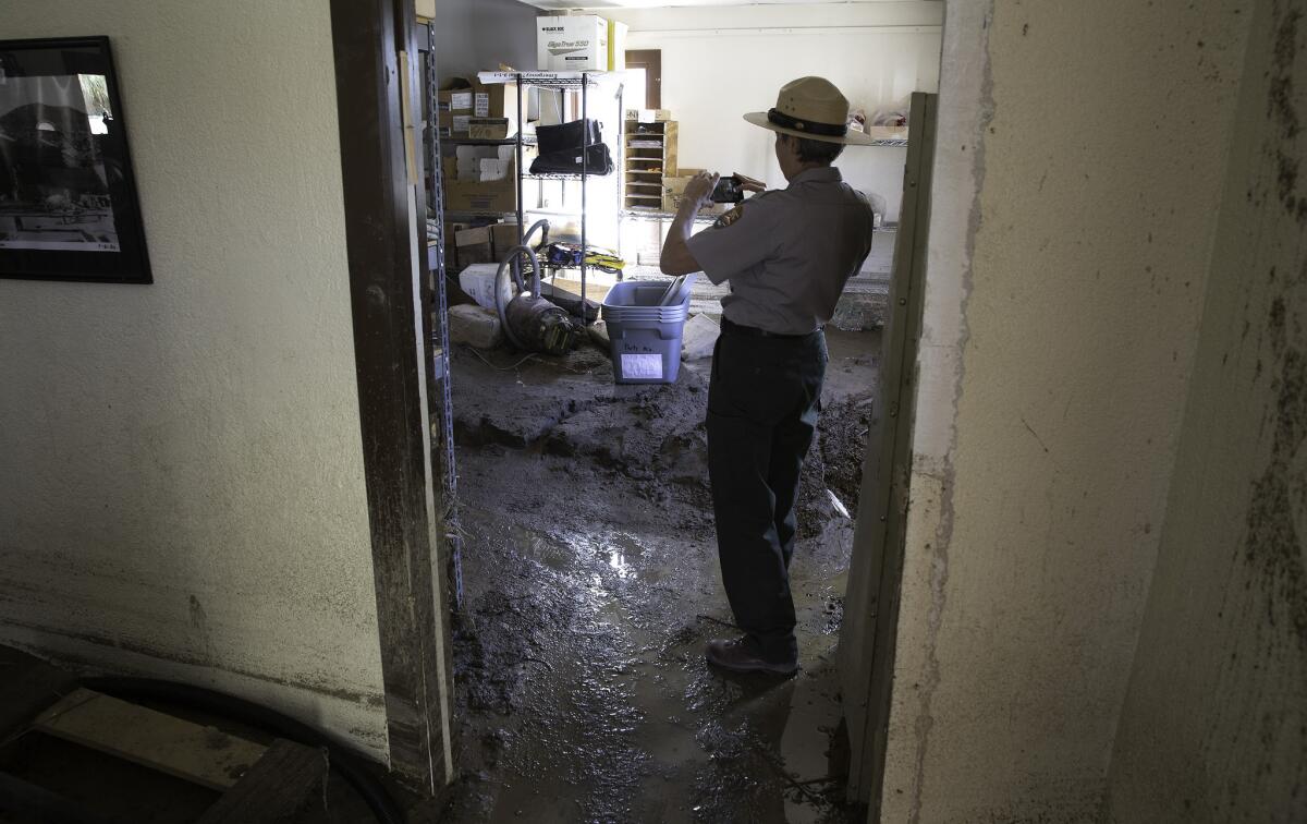 On Nov. 2, 2015, park ranger Linda Slater photographs damage caused by floodwaters inside the visitor center at Scotty's Castle.