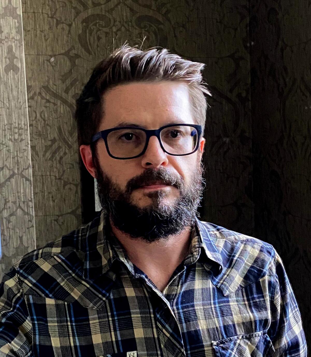 Brian Castleberry, successful a plaid garment and with glasses and a beard, looks into the camera.