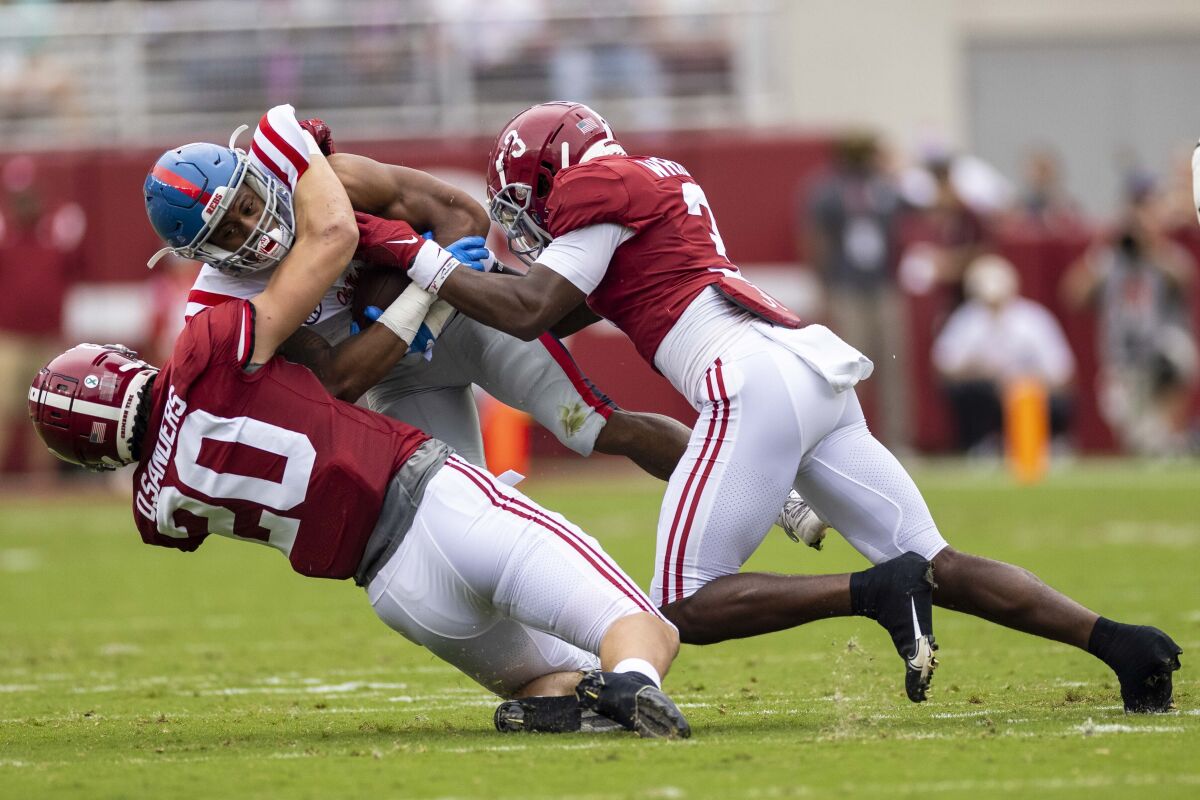 Alabama linebacker Drew Sanders (20) and Alabama defensive back Daniel Wright (3) tackle Mississippi running back Jerrion Ealy (9) during the first half of an NCAA college football game, Saturday, Oct. 2, 2021, in Tuscaloosa, Ala. (AP Photo/Vasha Hunt)