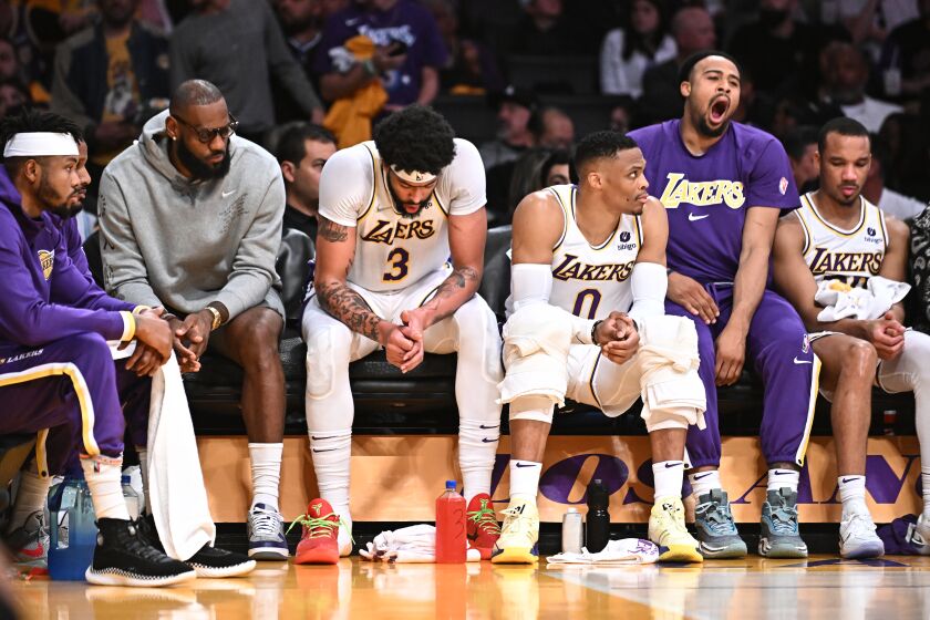 Los Angeles, California April 3, 2022- Lakers players including from left, LeBron James, Anthony Davis and Russell Westbrook sit with teammates on the bench late in the game against the Nuggets at Crypto.com Arena Sunday. (Wally Skalij/Los Angeles Times)