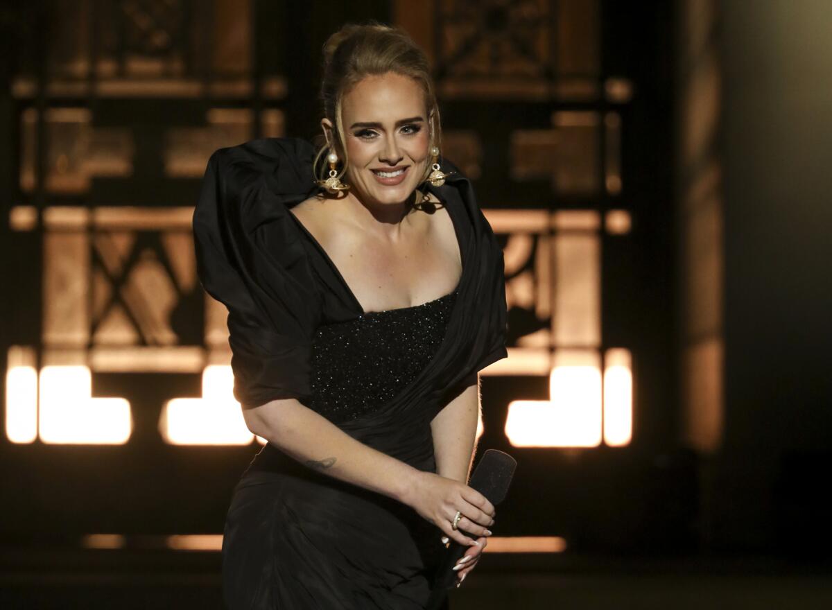 Adele wears a black gown and performs at the Griffith Observatory