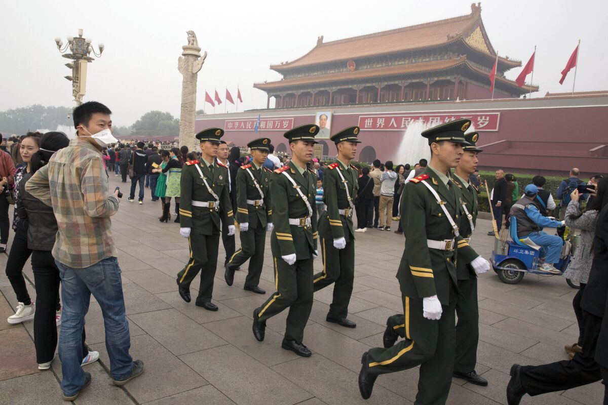 In this Oct. 11 photo, Chinese paramilitary police march across Tiananmen Gate in Beijing.