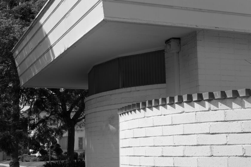 A black and white image of the Paul Williams Residence shows a curving wall with a serrated edge