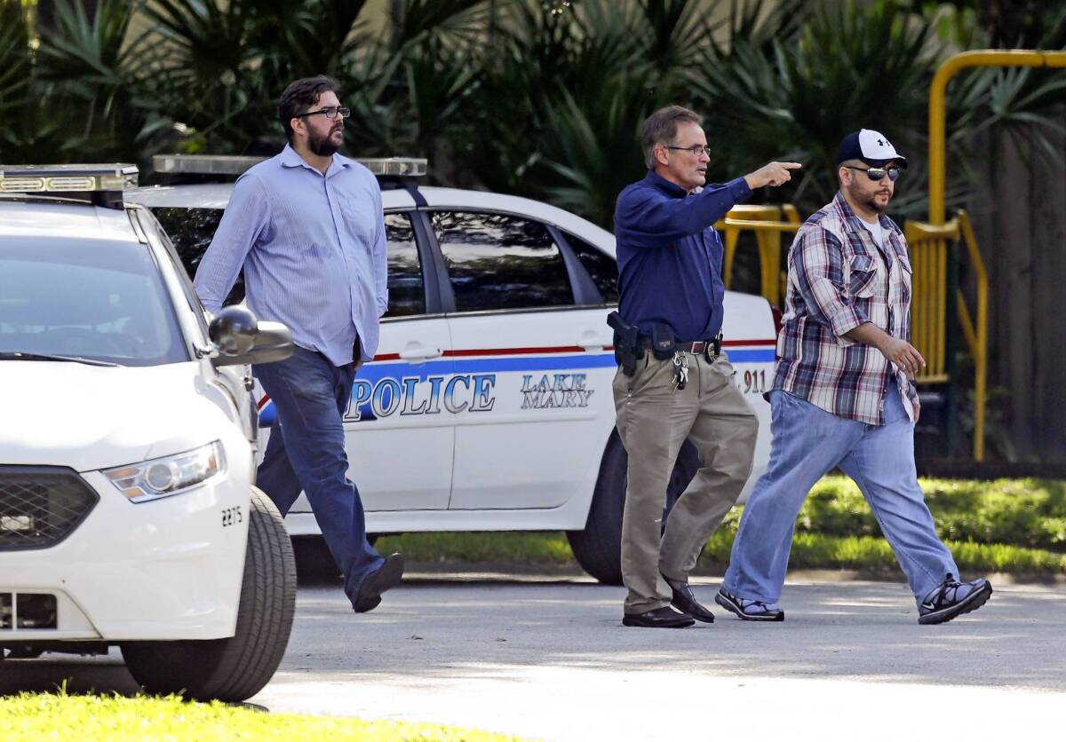 George Zimmerman, right, is escorted by a police officer in Lake Mary, Fla.