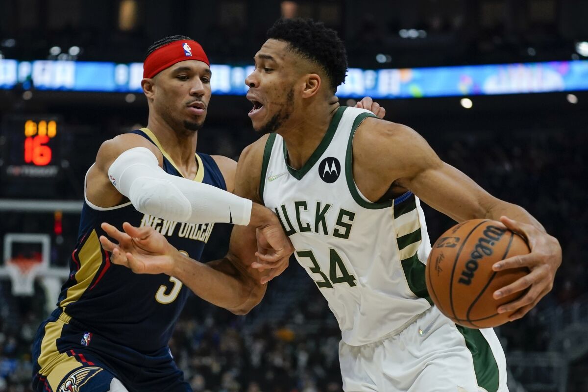 Milwaukee Bucks' Giannis Antetokounmpo tries to drive past New Orleans Pelicans' Willy Hernangomez during the first half of an NBA basketball game Saturday, Jan. 1, 2022, in Milwaukee. (AP Photo/Morry Gash)
