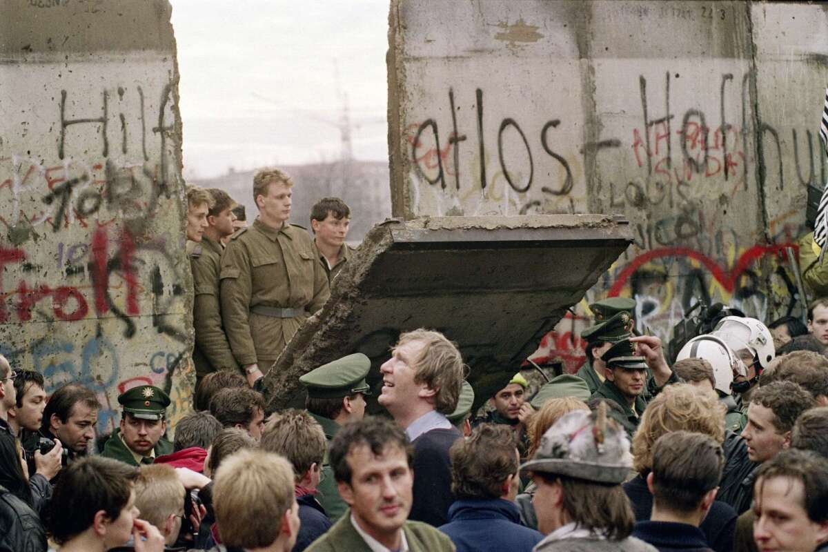 A crowd in West Berlin watches East German border guards demolish the Berlin Wall near Potsdamer Platz in November 1989.