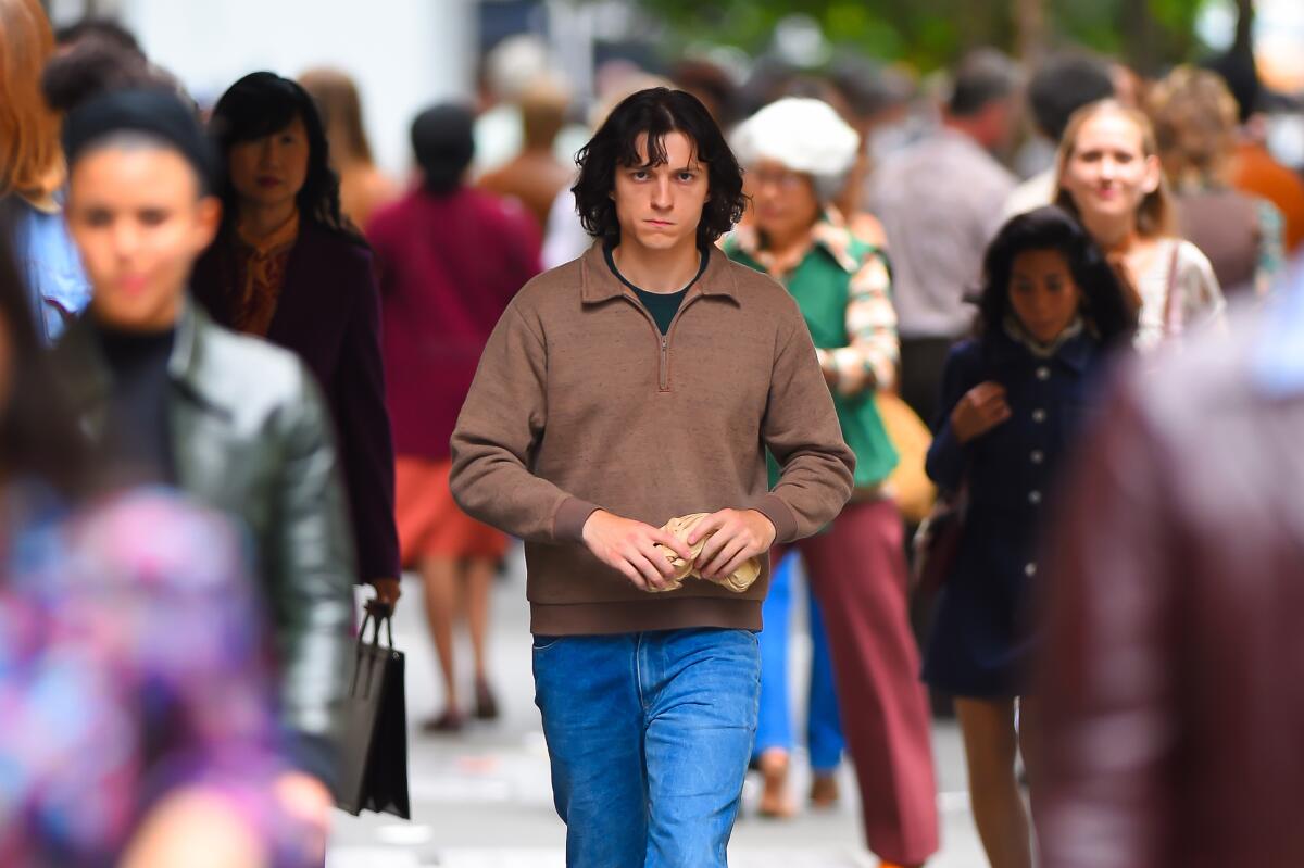 A man, center, walking a crowded street.