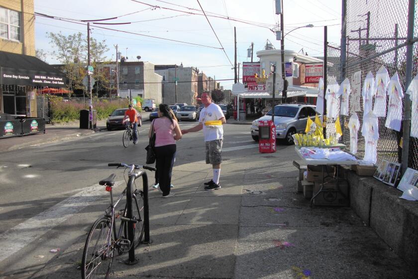 Michael "Puge" Puggi, 40, sells Vatican flags on a busy corner in South Philadelphia.