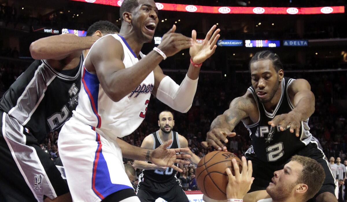 Clippers point guard Chris Paul calls for a timeout as Spurs forward Kawhi Leonard tries to steal the ball from af allen Blake Griffin.